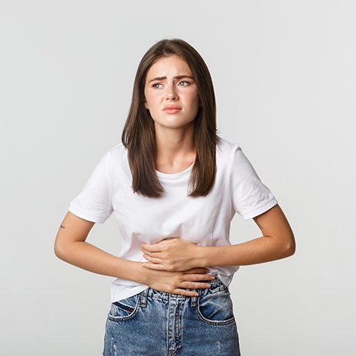 Woman having stomach ache, bending and holding hands on belly, discomfort from menstrual cramps.